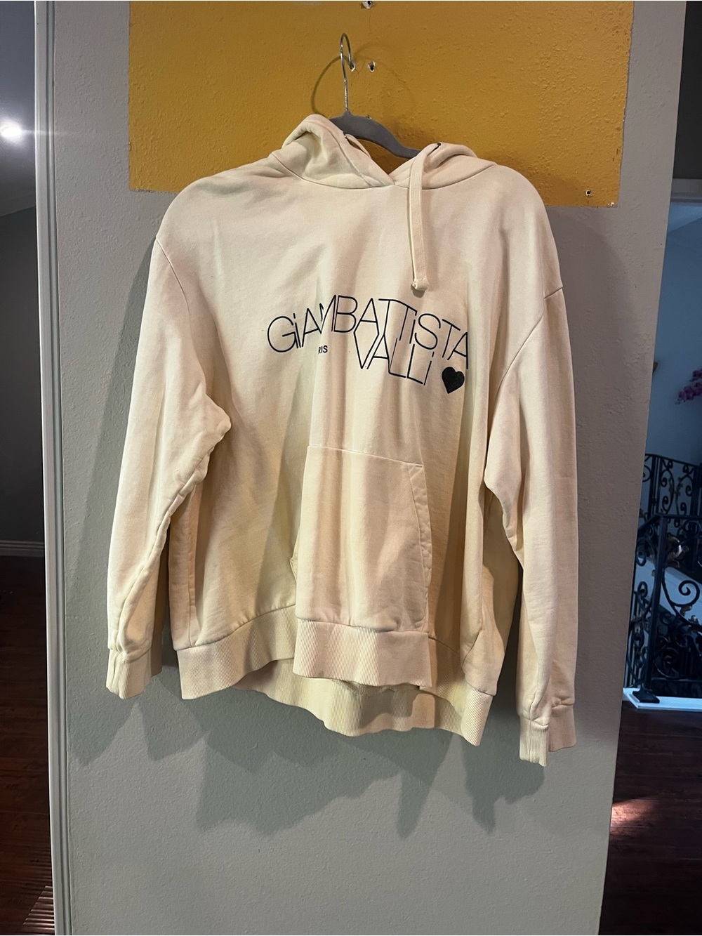 Soft cream pullover hoodie with front kangaroo pocket.